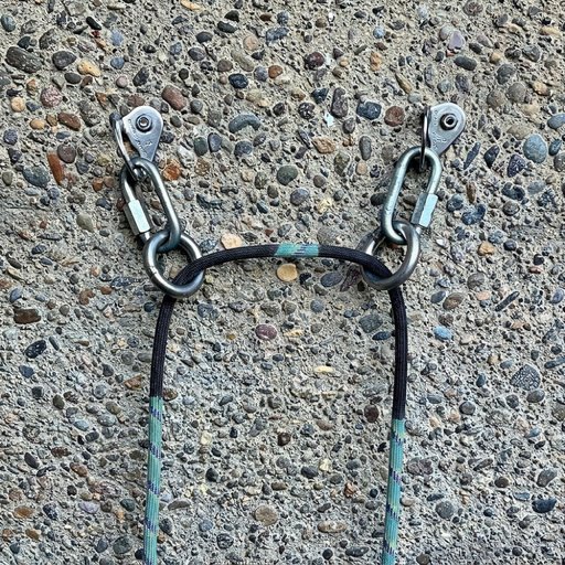 Two bolts, each with a quick link and a ring. The rope runs through both rings, which hang free to
                  align with the rope.