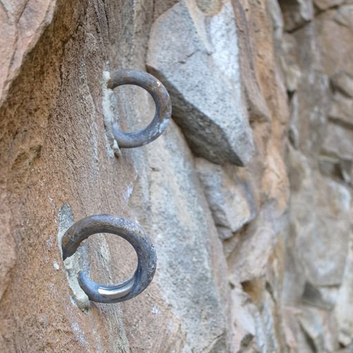Two large steel rings fixed in a rock face, one above the other, free to swivel in their eyes.