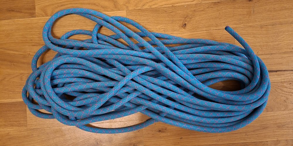 The same blue rope coiled with its loops crossing over in a figure-eight pattern.