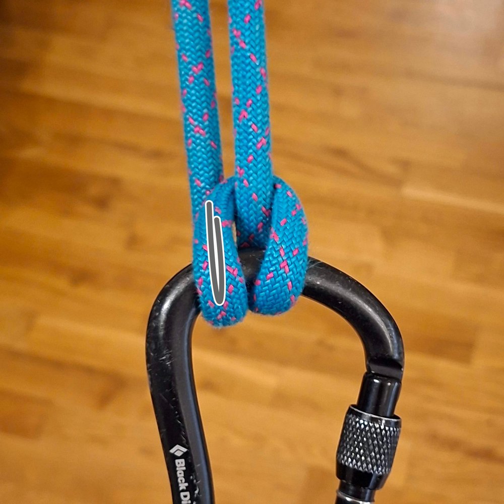 The Munter hitch with the brake strand held straight up alongside the loaded strand. A gray line
                  marks a flat bend.